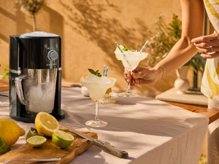 Aparat za drobljenje leda i dva koktela margarita na sunčanom stolu.