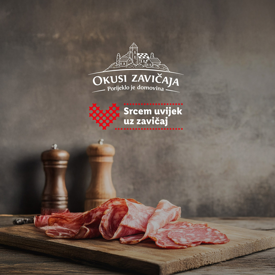 Narezana sušena salama i kobasica na drvenoj dasci, s logotipom Okusi Zavičaja.