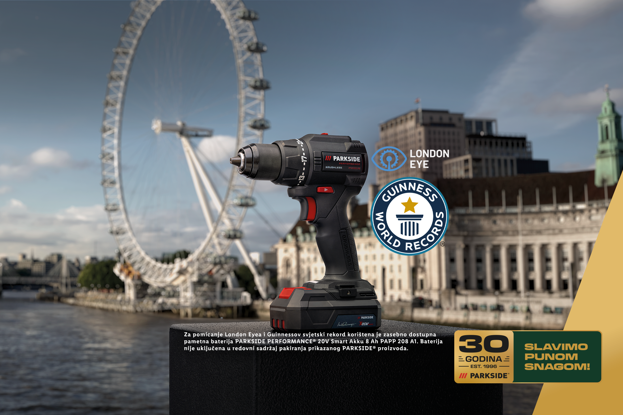 Akumulatorska bušilica na pozadini London Eyea, s natpisom '30 godina, slavimo punom snagom!'