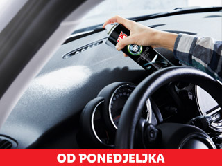 Osoba prska sprej za čišćenje armaturne ploče u automobilu.